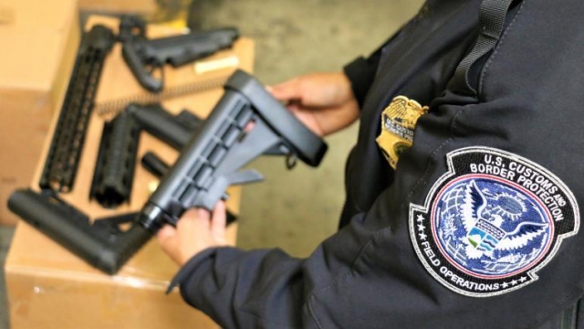 Border Patrol agent holding seized gun parts