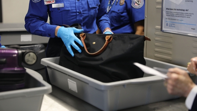 A TSA agent checks a bag