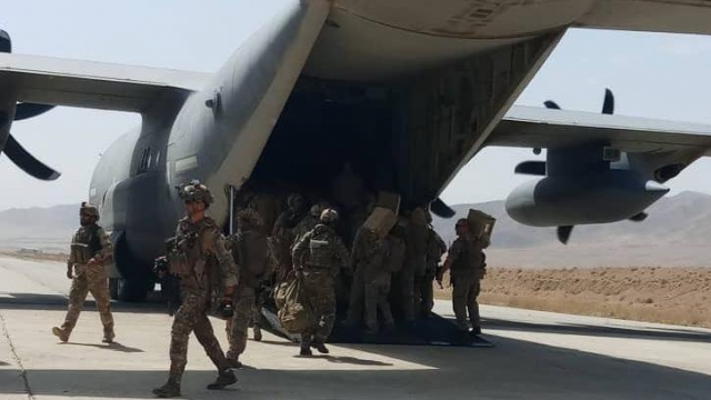 Afghan forces unload a plane