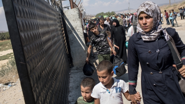 Syrian refugees approach border gate in Kilis, Turkey.
