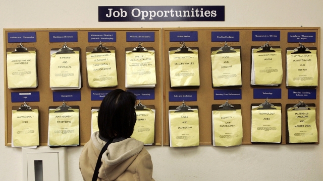 A woman looks at hiring notices