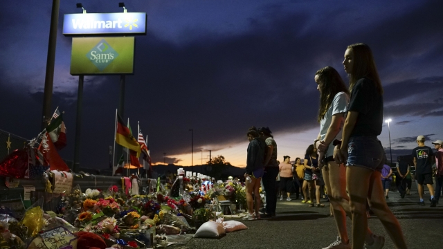 People gather around a memorial for victims outside Walmart in El Paso, Texas