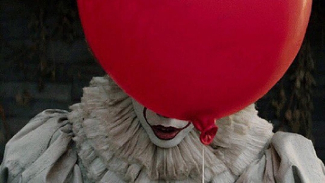 Nightmare clown behind red balloon.
