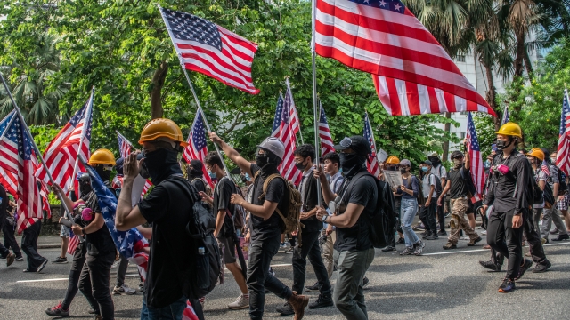 Hong Kong protesters carry American flags on their way to the U.S. consulate
