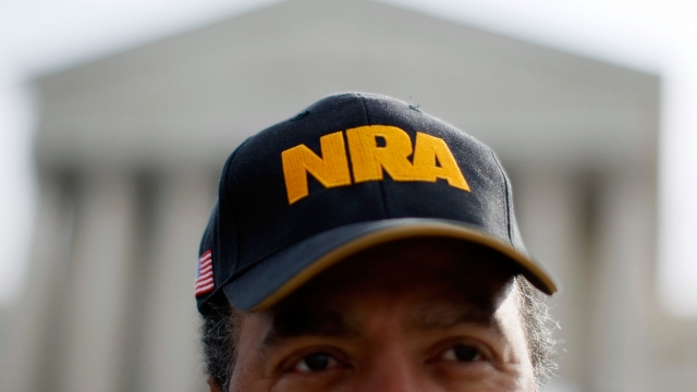 A man wears an NRA hat
