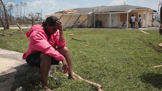 Bahamian woman near damaged home