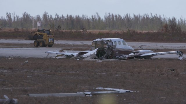 A destroyed airplane sits near the runway at Freeport's airport.
