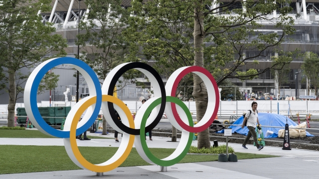 A man looks at the Olympic rings displayed in front of the New National Stadium, the main venue for the Tokyo 2020 Olympics