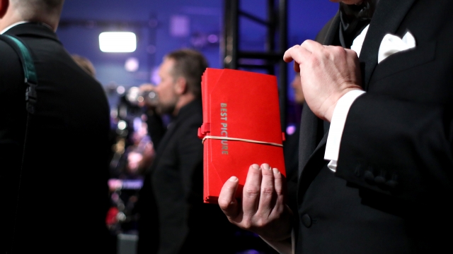 Man holds Oscar envelope for best picture.