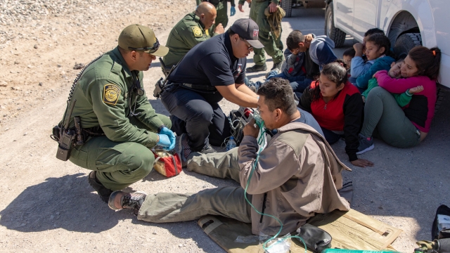 U.S. Border Patrol agents render medical aid to migrants traveling with a group that crossed the border illegally