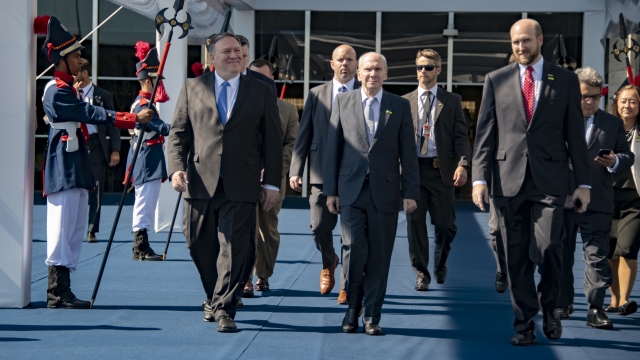 Secretary of State Mike Pompeo walks with adviser Michael McKinley