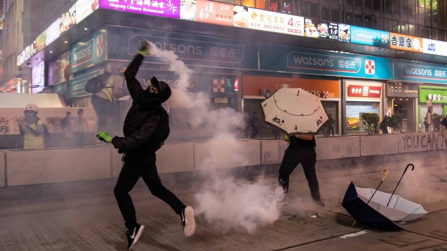 Protester hurls a tear gas canister near restaurants and businesses in Hong Kong on Oct. 27.
