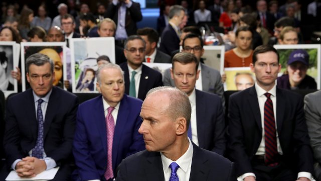 Families of passengers on two deadly 737 Max crashes hold images of their loved ones as Boeing's CEO prepares to testify