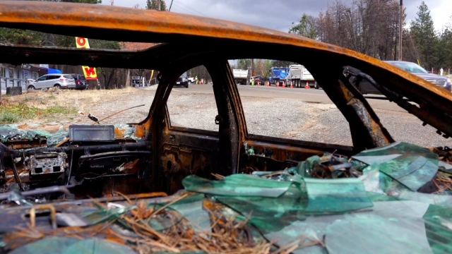 Crews removed debris near burned out cars in Paradise, California.