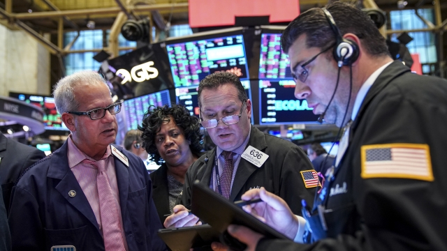 Traders and financial professionals work on the floor of the New York Stock Exchange at the closing bell on October 30