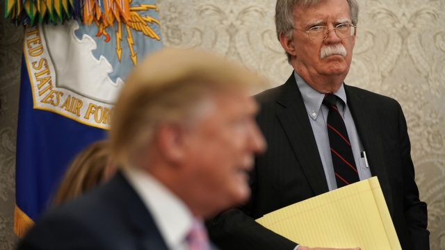 Former National Security Adviser John Bolton listens to President Trump during a meeting in the Oval Office