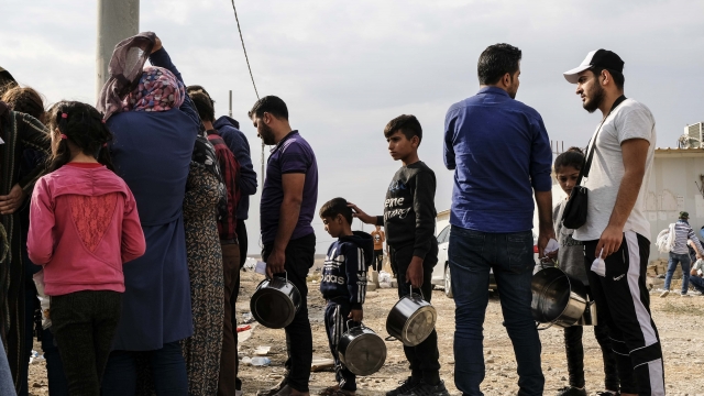 Syrian refugees wait to receive food and water at the Bardarash camp