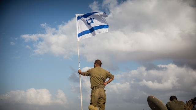 An Israel soldier stands on top of an armored personal carrier near the Israeli-Gaza border