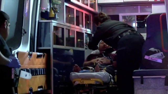 A man is treated in the back of an ambulance after a shooting in Fresno, California.