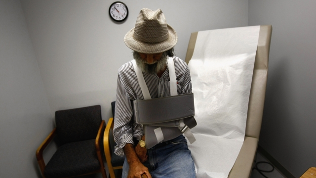 An elderly man sits in an medical exam room