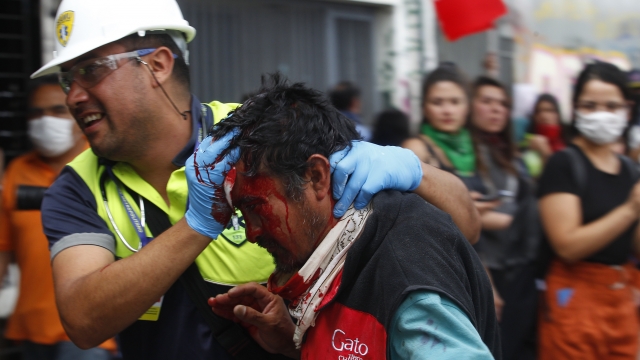 A Red Cross medic attends to man injured by a pellet during Chilean street protests.