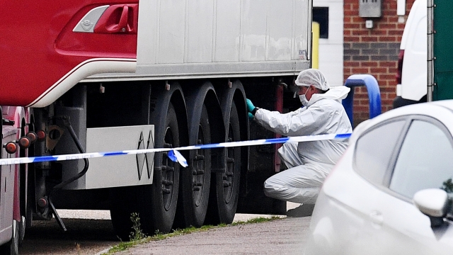 Forensic officers investigate a truck in which 39 bodies were discovered in the trailer