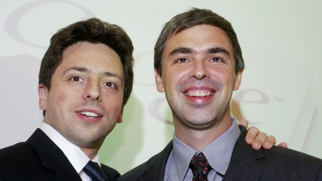 Google founders Sergey Brin and Larry Page smile prior to a news conference