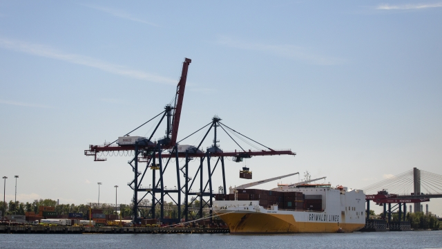 Cranes load shipping containers onto a cargo ship in Staten Island.