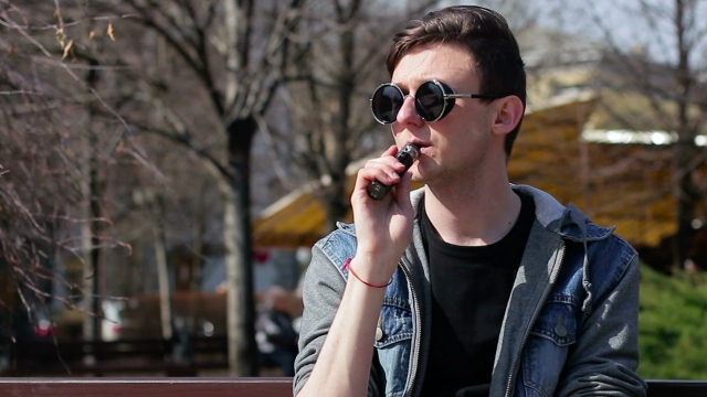 A teen smokes from an electronic cigarette.