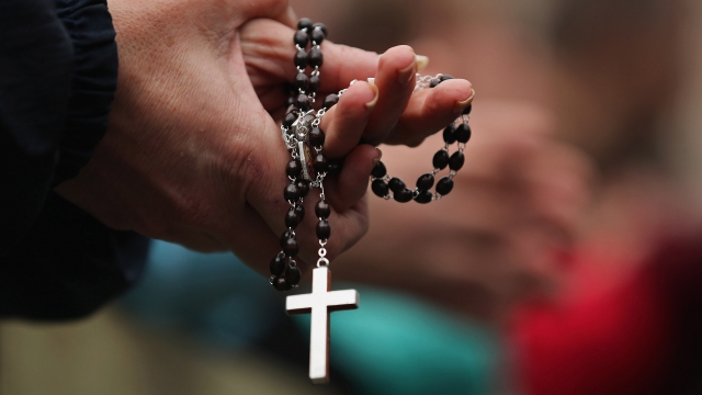 A woman holds rosary beads