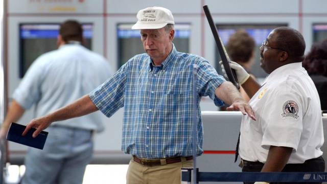 A TSA employee screens an airport passenger