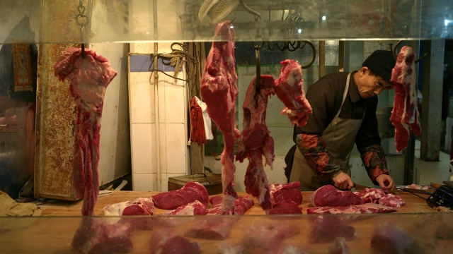 A man cutting pork