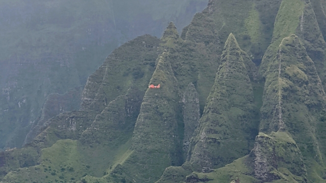 A Coast Guard aircraft searching in the mountains of Kauai