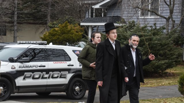 People walk down the street near the house of Rabbi Chaim Rottenberg.