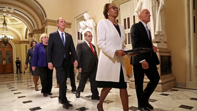 House of Representatives officials walk articles of impeachment across the Capitol.