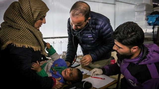 Syrian-American humanitarian doctor Zaher Sahloul treats a baby at a camp for displaced people in Idlib, Syria.