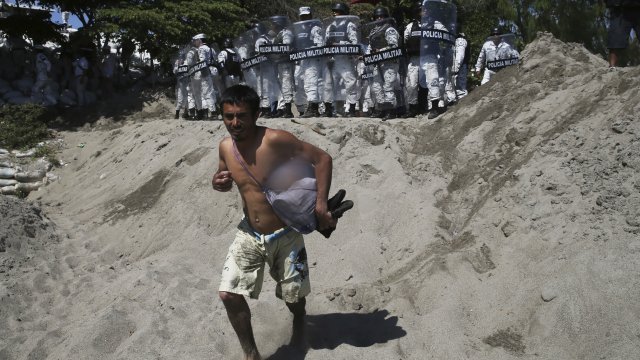 A Central American migrant is blocked by Mexican troops from entering Mexico after crossing the Suchiate River