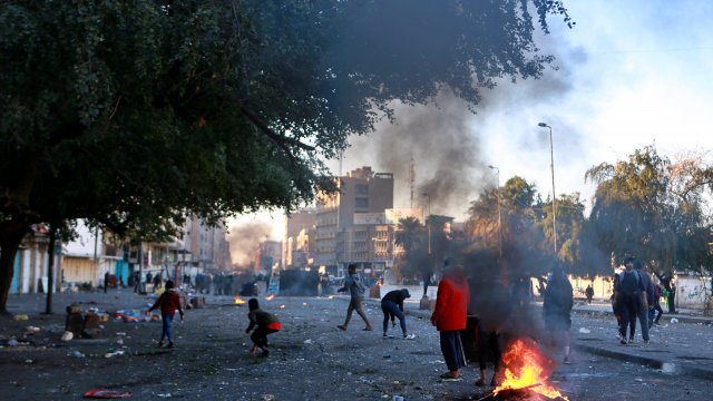 Protesters set fire to close a street during clashes between security forces and anti-government protesters.