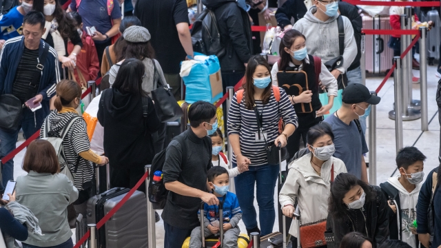 Travelers wearing face masks at a station.
