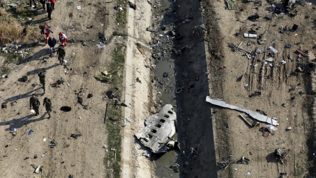Rescue workers search the scene where a Ukrainian plane crashed