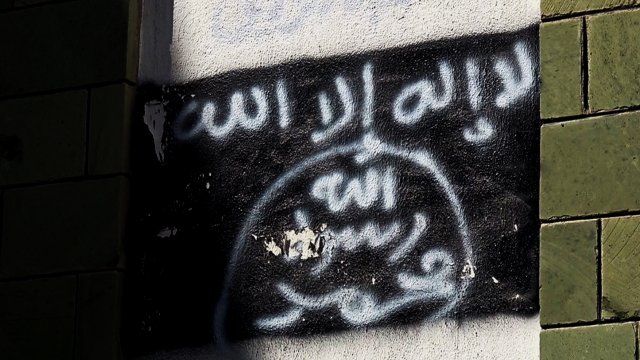 Al-Qaeda flag spray-painted on a wall.