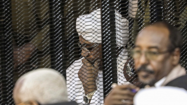 Omar al-Bashir sits in cage during corruption trial