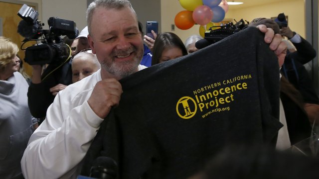 Ricky Davis holds up a shirt with the logo of the Innocence Project after he was released from custody.