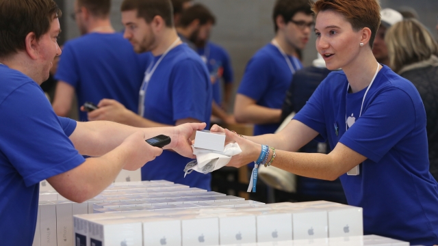 Apple store sales assistants help hand out new iPhones