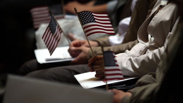 People holding American flags during naturalization ceremony