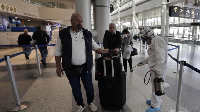 Amid coronavirus fears, international traveler's luggage is sprayed with disinfectant in Lebanon.