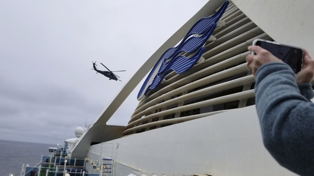 A helicopter flies over the Grand Princess cruise ship