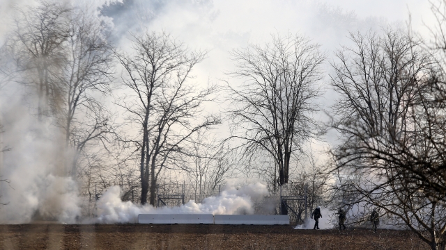 Greek riot police police are seen through smoke during clashes at the Greek-Turkish border