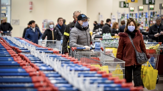 People wear masks at a supermarket in Milan, Italy on Sunday, March 8, 2020