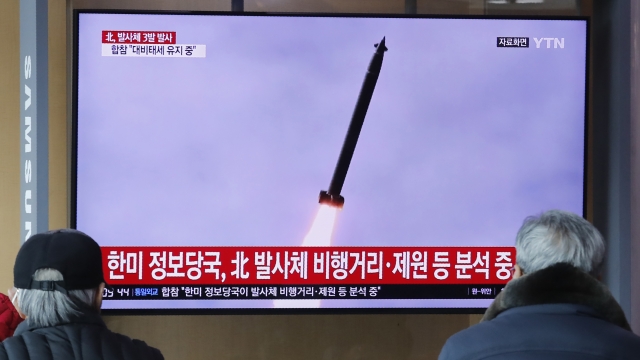 People watch a TV showing a file image of an unspecified North Korea's missile launch